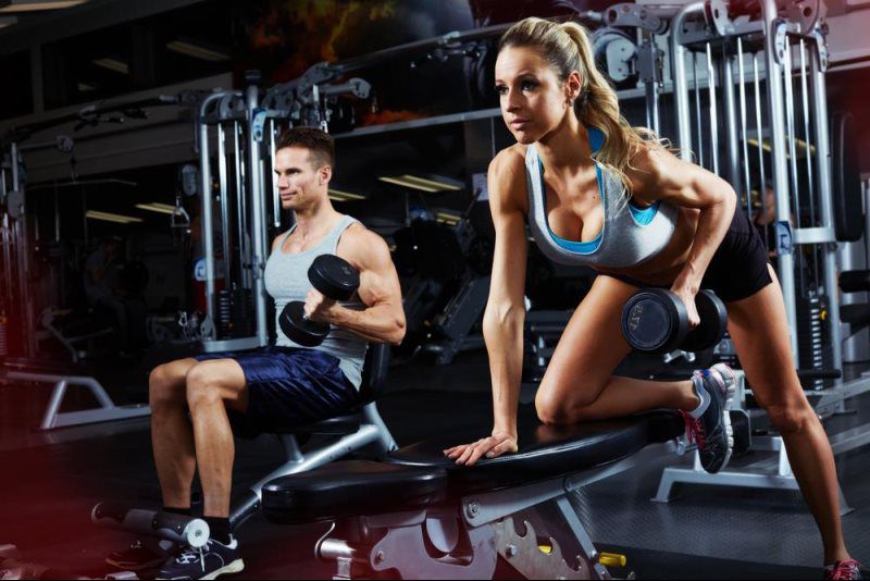 man and woman lifting dumbbells